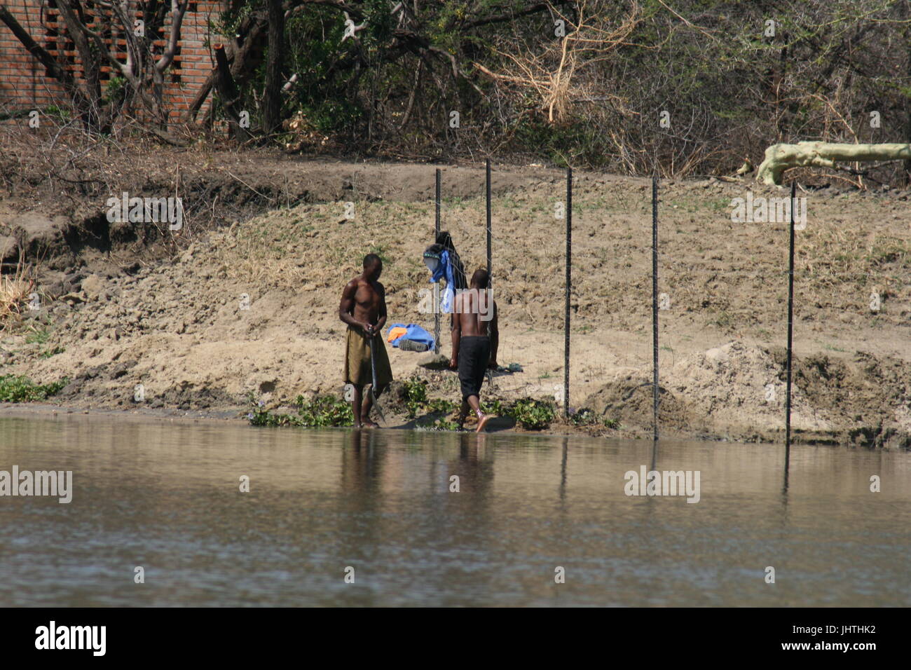 Afrikanische Männer arbeiten im Fluss von Nilpferd und Krokodil besetzt Stockfoto