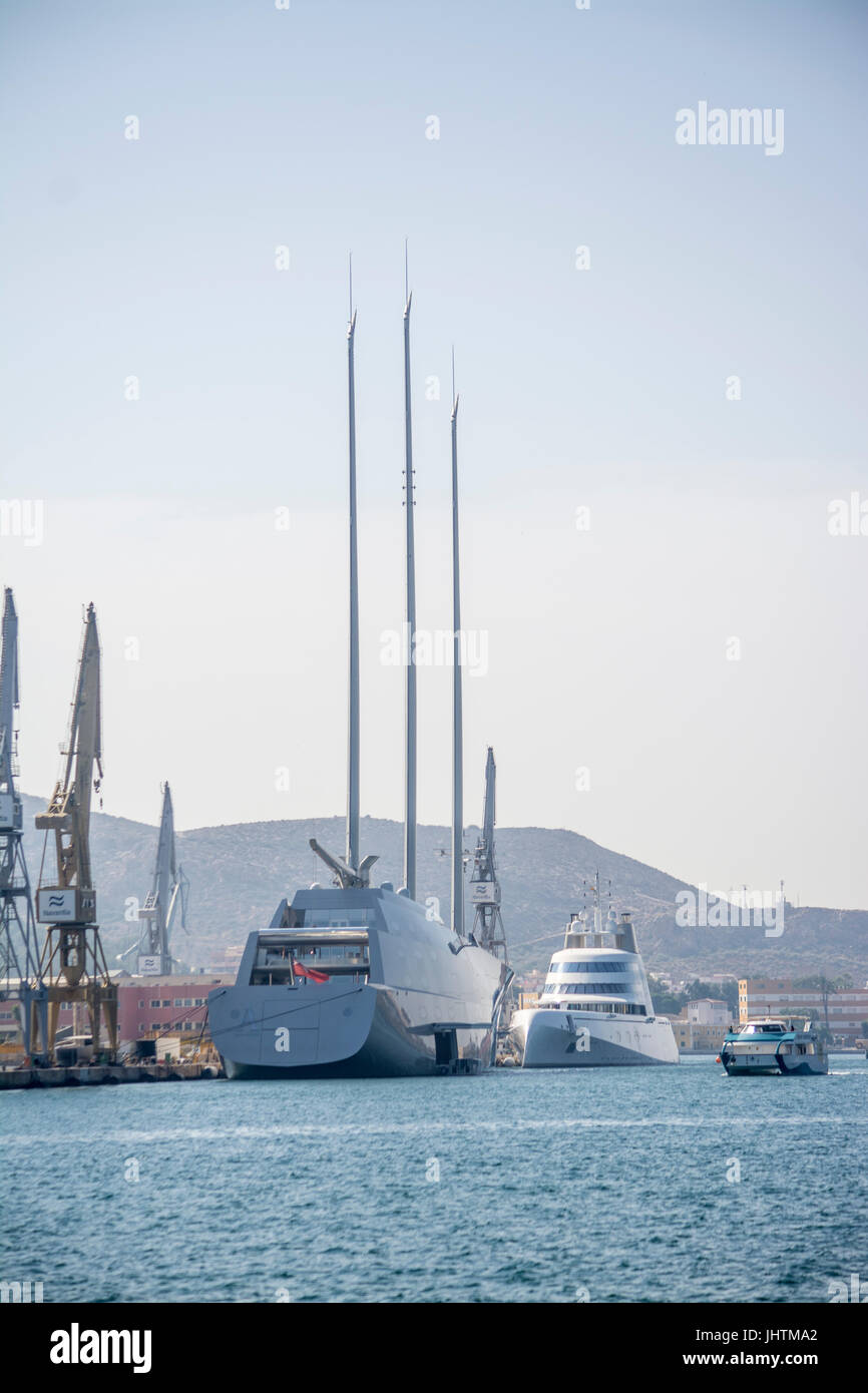 Tourist-Katamaran Segel vorbei an der 'A' Segelyacht und 'A' Motoryacht, zwei der weltweit teuersten Superyachten im Hafen von Cartagena vertäut Stockfoto