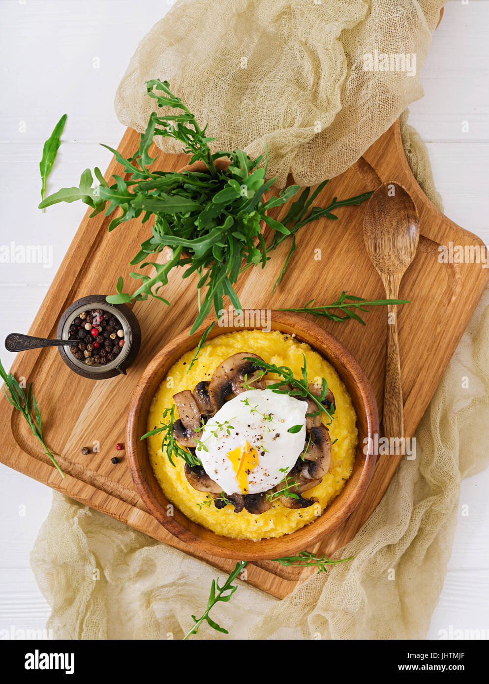 Frühstück. Polenta mit Pilzen und pochiertem Ei. Flach zu legen. Ansicht von oben. Stockfoto