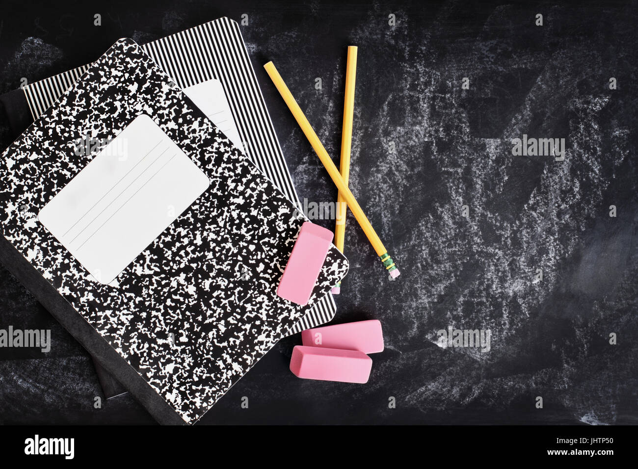 Zurück in der Schule liefert. Bücher, Radiergummis und Bleistifte über eine Tafel oder Tafel mit Platz für Textfreiraum. Stockfoto
