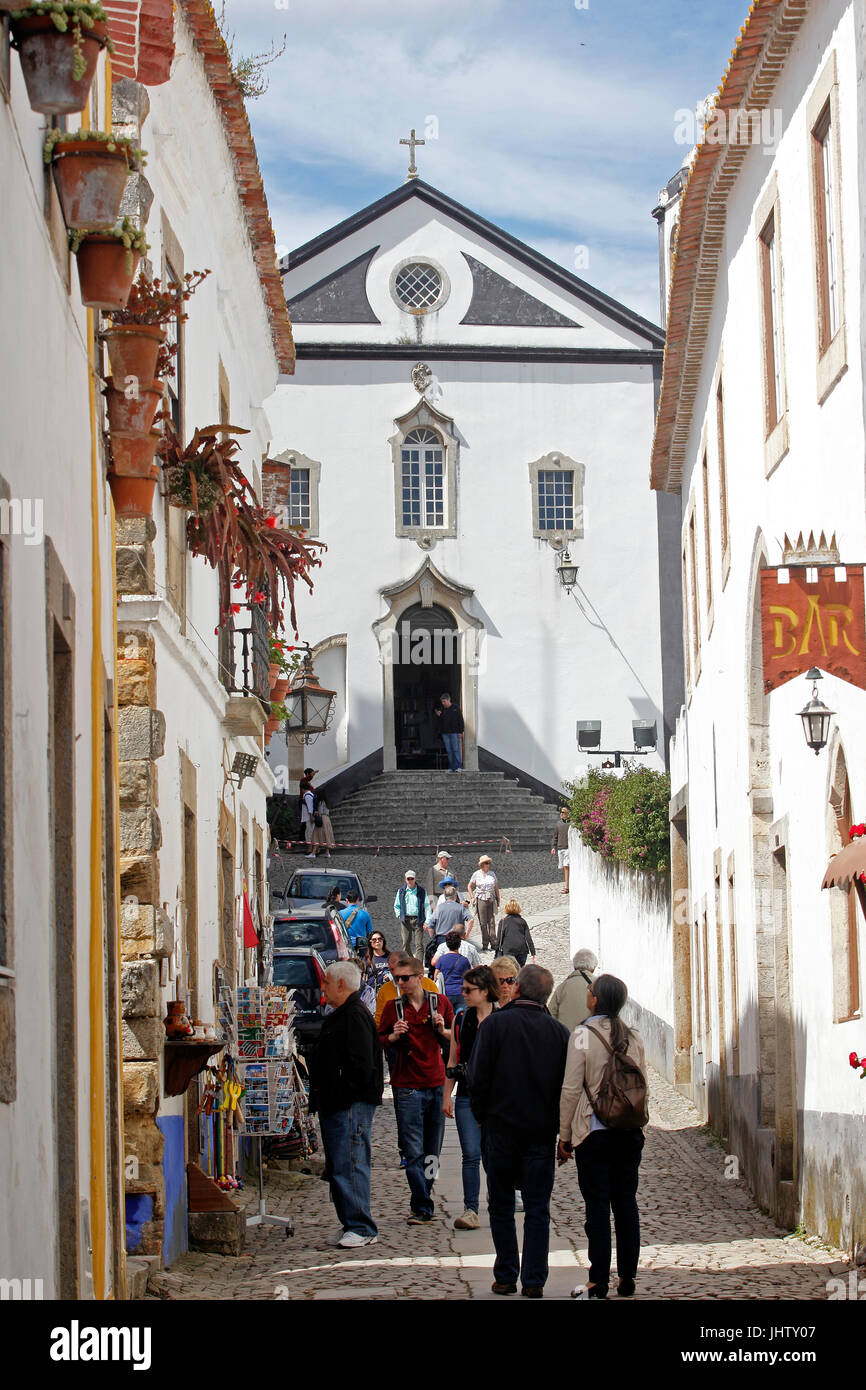 Touristen strömen zu den Geschäften auf der schmalen gepflasterten Straßen weiß getünchten Dorf Obidos Estremadura Portugal Stockfoto