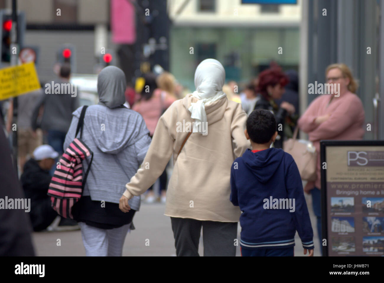 Asiatische Familie Flüchtling junge Frau Mädchen Schüler Schüler gekleidet Hijab Schal auf Straße in der UK alltägliche Szene gehen auf der Straße Stockfoto