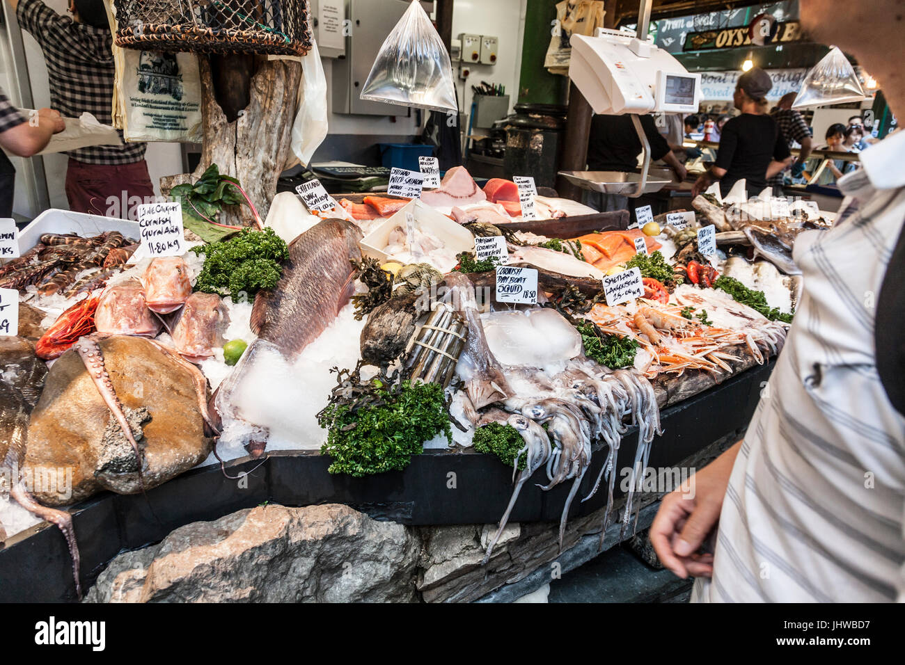 Kunden auf einem nassen Fisch Stall im Borough Market, dem historischen Lebensmittelmarkt in Southwark, zentrales London, England, UK. Stockfoto