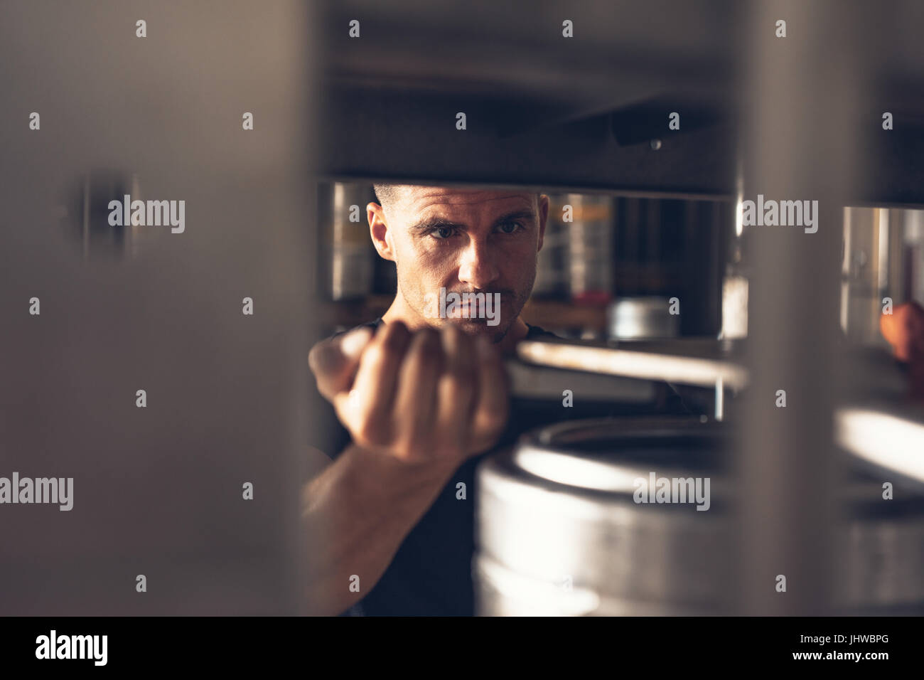 Mann in Brauerei Fabrik gearbeitet. Mitarbeiter der Produktionslinie Abfülllinie Aluminium Fass aufsetzen. Stockfoto