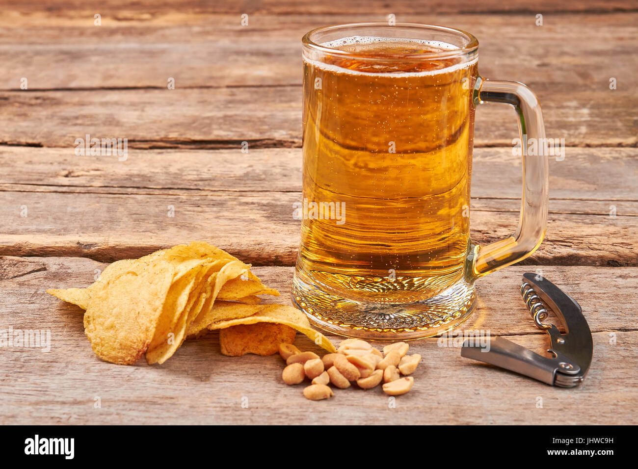 Glas Bier, Chips, Nüssen, Korkenzieher. Stockfoto