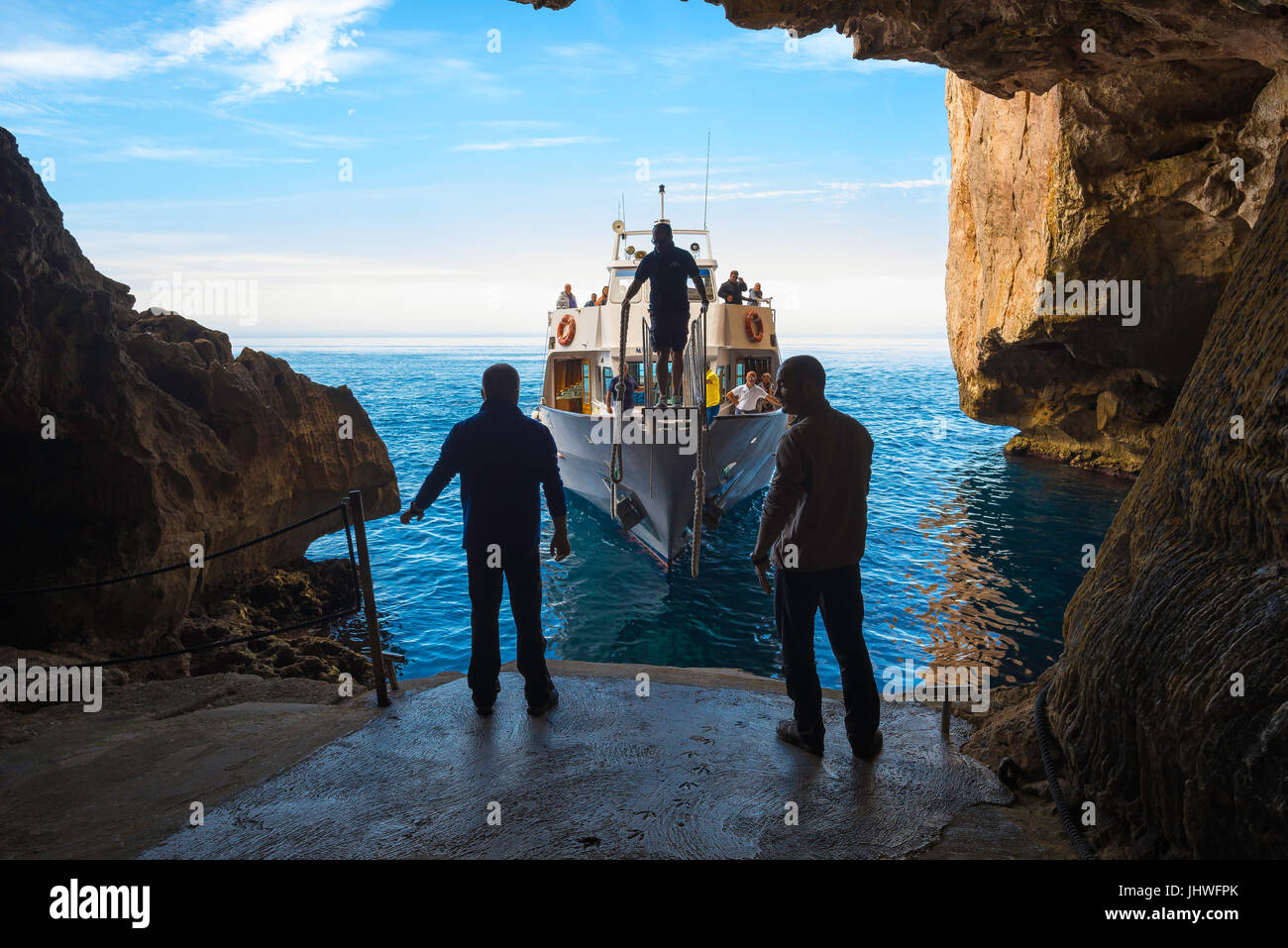 Sardinien Küste Tourismus, bereiten zwei Männer auf einer Tour Bootsanlegestelle die Grotta di Nettuno am Capo Caccia in der Nähe von Alghero, Sardinien angekommen. Stockfoto