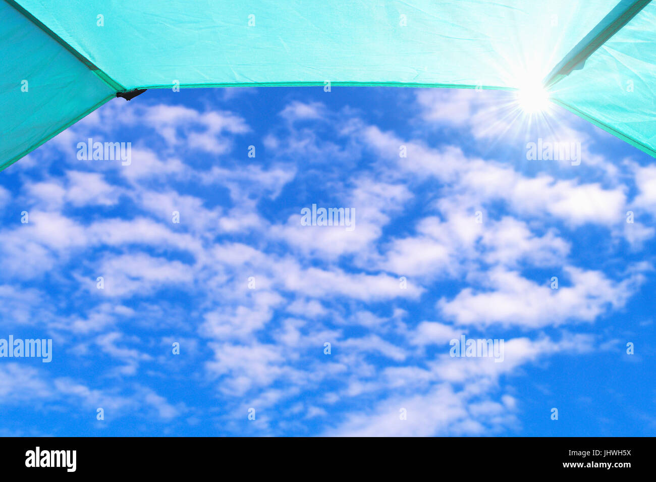 Blauer Himmel mit weißen Wolken und Strahlen der Sonne aus gesehen, in einem Zelt. Sommer Reisen Hintergrund Rahmenkonzept. Stockfoto