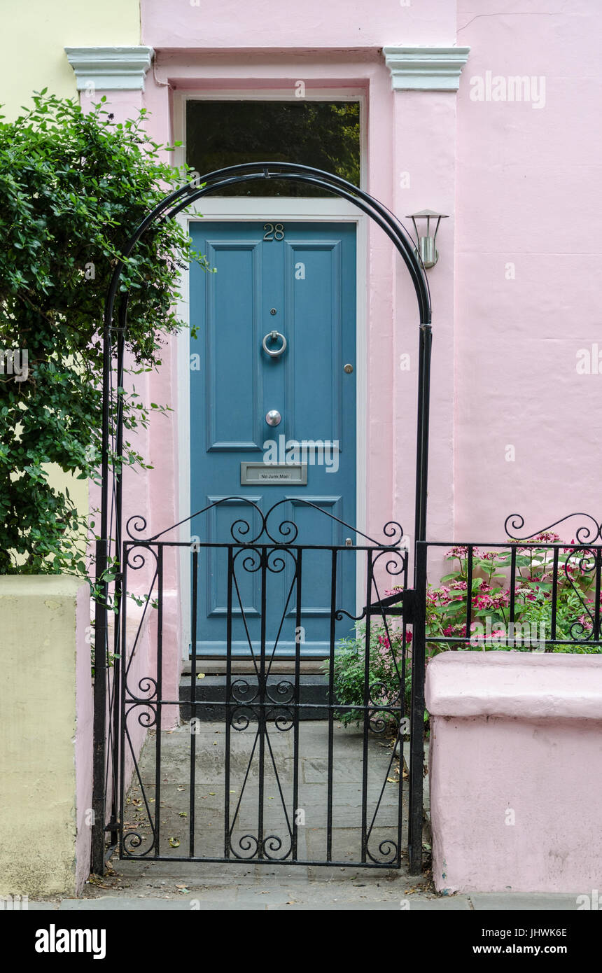 N0. 28 Portobello Road in Notting Hill, London verfügt über eine türkise Tür, rosa Wände und ein attraktives schwarzes Eisentor. Stockfoto
