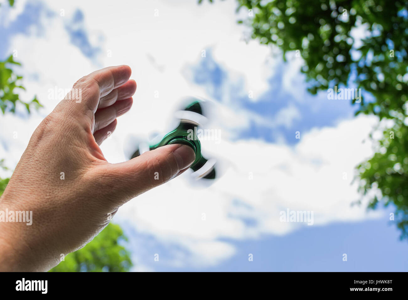 Männliche hand mit rotierenden zappeln Spinner gegen Sky Stockfoto