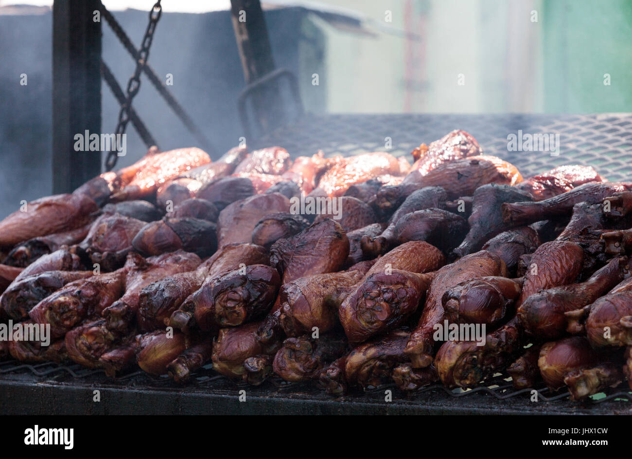 Türkei-Beine auf einem Grill kochen auf einem Messegelände geraucht. Stockfoto