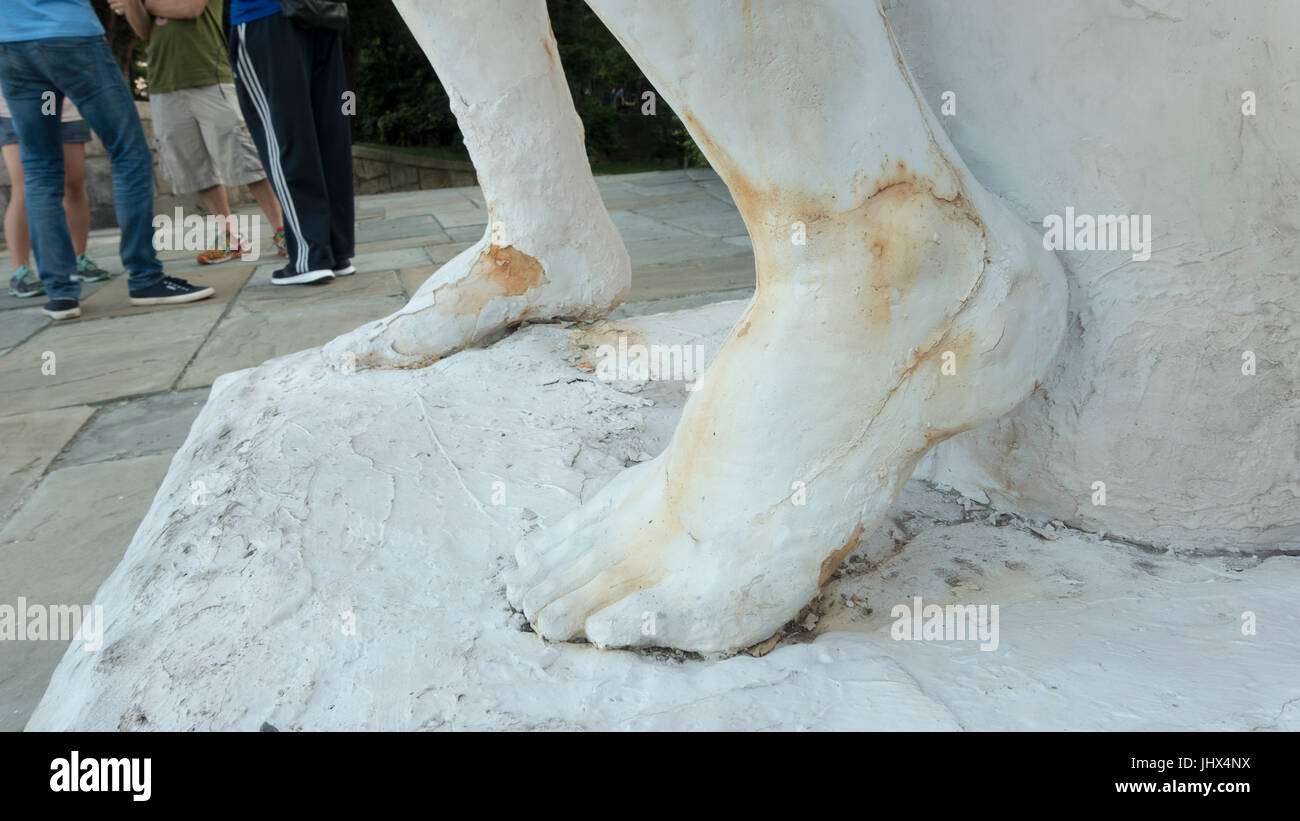 verwitterte weiß keuchend Eisenskulptur, Rostflecken, die Füße der Leute Füße verschwommen im Hintergrund Stockfoto