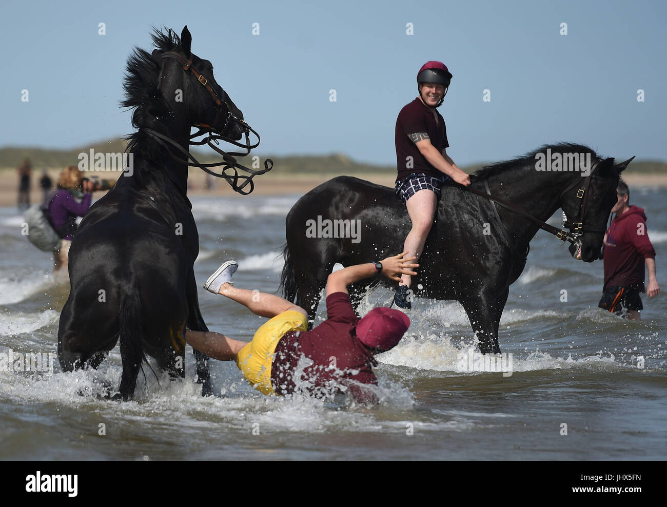 Ein Fahrer aus dem Haushalt Kavallerie montiert Regiment ist von seinem Pferd geworfen, wie sie das jährliche Regimental Training am Holkham Beach in Norfolk teilnehmen. Stockfoto
