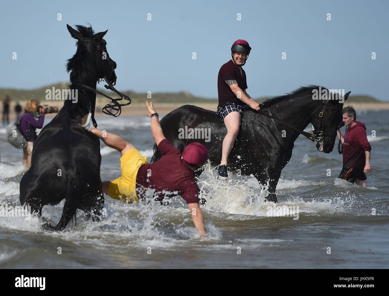 Ein Fahrer aus dem Haushalt Kavallerie montiert Regiment ist von seinem Pferd geworfen, wie sie das jährliche Regimental Training am Holkham Beach in Norfolk teilnehmen. Stockfoto