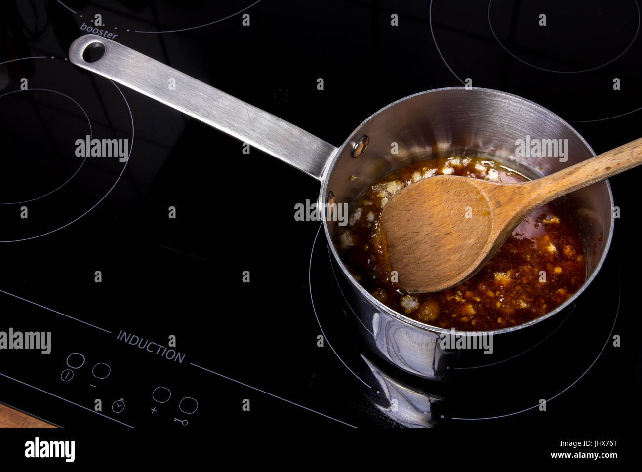 Topf mit CombineObject weißen Zucker auf ein Induktions-Kochfeld Stockfoto