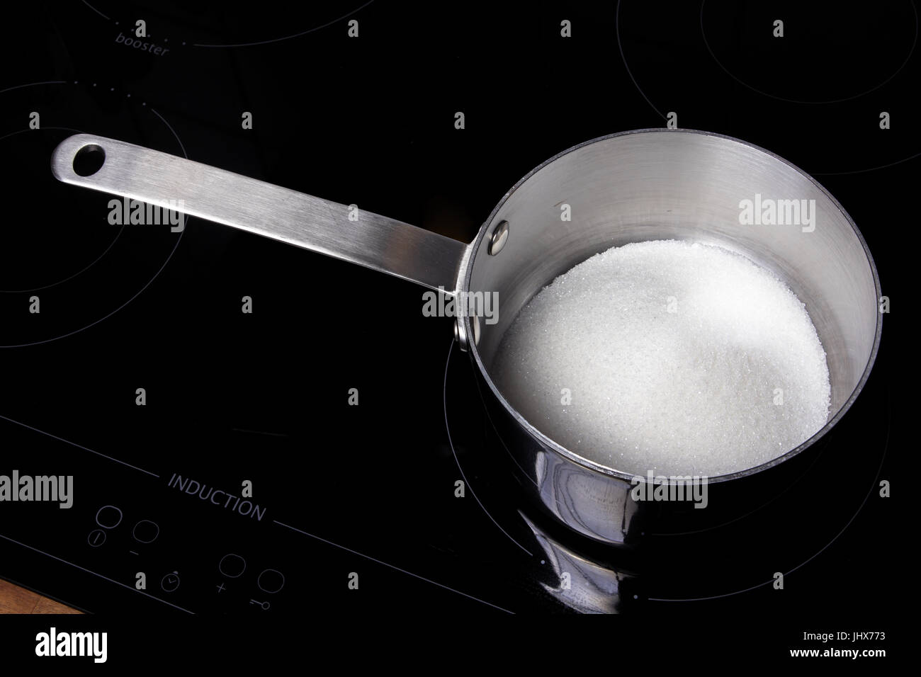 Topf mit weißen Zucker auf ein Induktions-Kochfeld Stockfoto