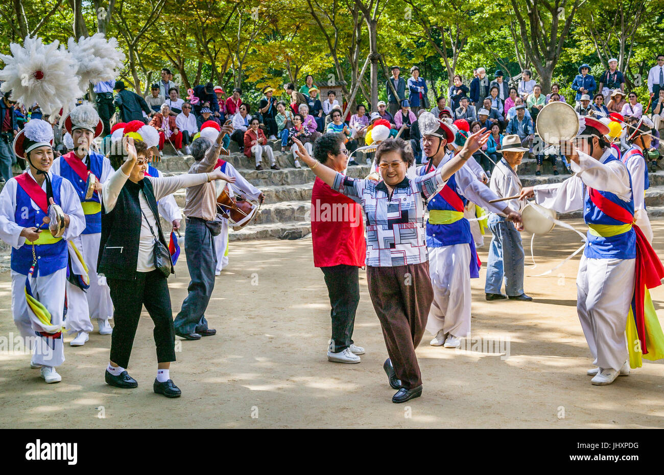 Republik Korea, Suwon, Korean Folk Village, Touristen an einen Bauern Tanz teilnehmen Stockfoto