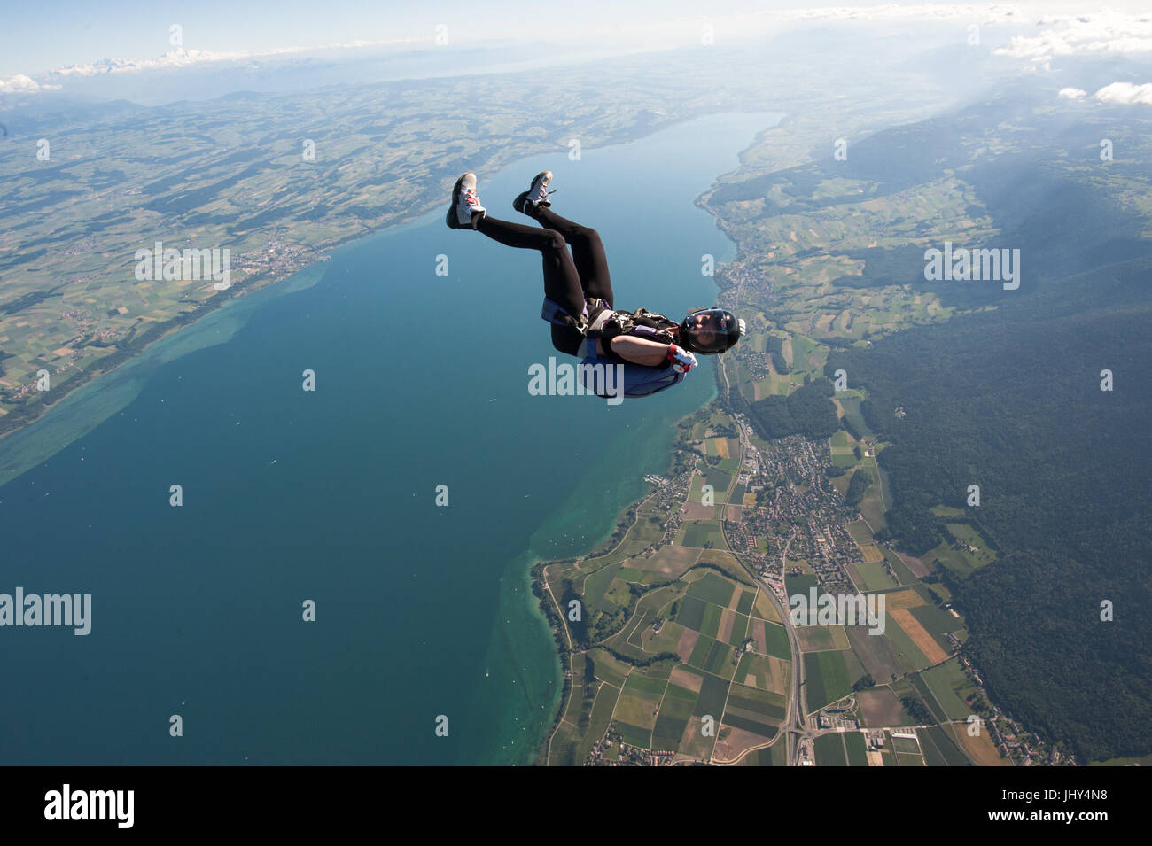 Eine Frau macht ein lustiges Fallschirmspringen über dem Neuenburgersee in der Schweiz Stockfoto