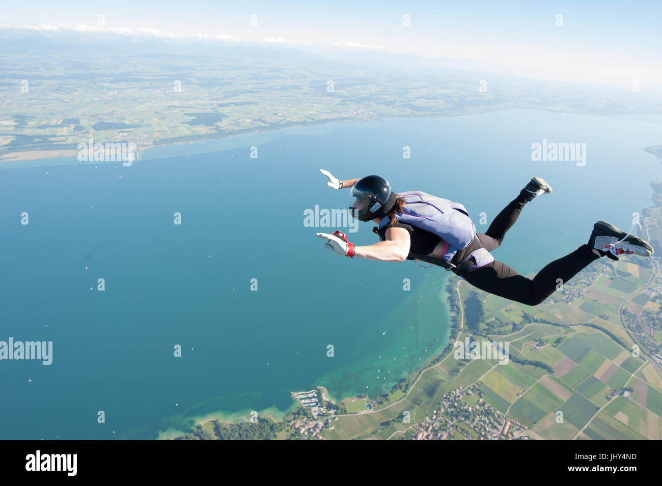 Eine Frau macht ein lustiges Fallschirmspringen über dem Neuenburgersee in der Schweiz Stockfoto