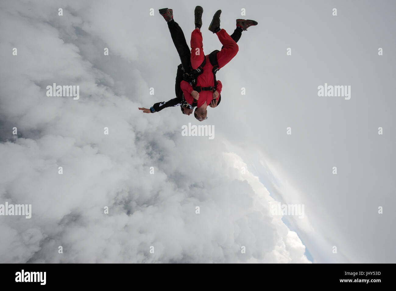 Ein Tandemlehrer nehmen einen Passagier für seinen ersten Fallschirmsprung Stockfoto