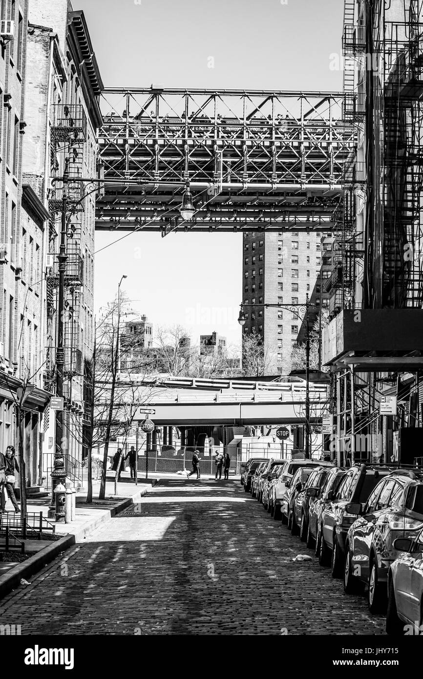 Straßenschlucht mit Brooklyn Bridge in Downtown Manhattan - MANHATTAN / NEW YORK - 2. April 2017 Stockfoto