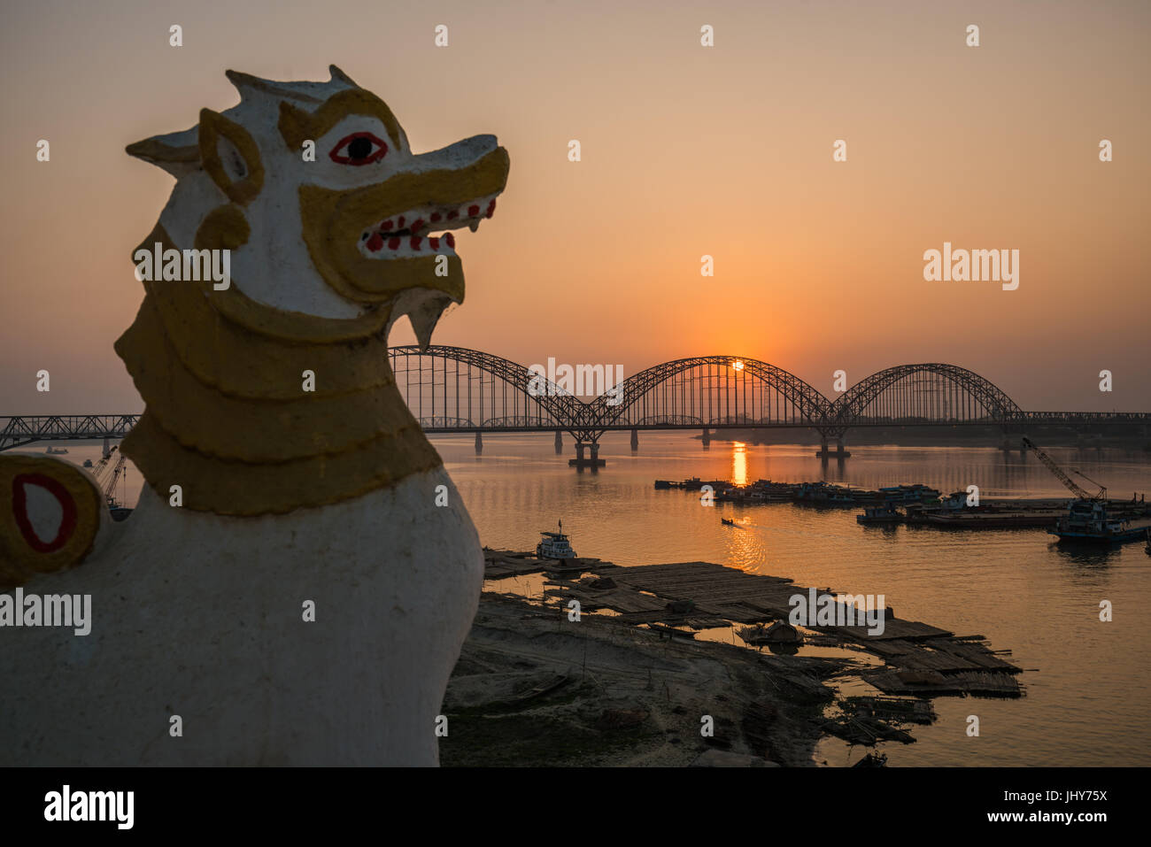 Löwen-Statue in der Nähe von Yadanarbon Brücke bei Sonnenuntergang über Ayeyarwady Fluss, moderne Brücke in Mandalay-Division, Burma Stockfoto