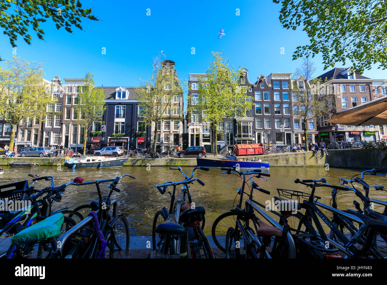 Fahrräder parken an den Ufern des Flusses Amstel und typische Häuser, Amsterdam, Holland (Niederlande), Europa Stockfoto