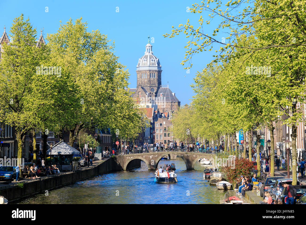 Die alte Kirche (Oude Kerk) eingerahmt von Booten und Brücken in einem Kanal des Flusses Amstel, Amsterdam, Holland (Niederlande) Stockfoto