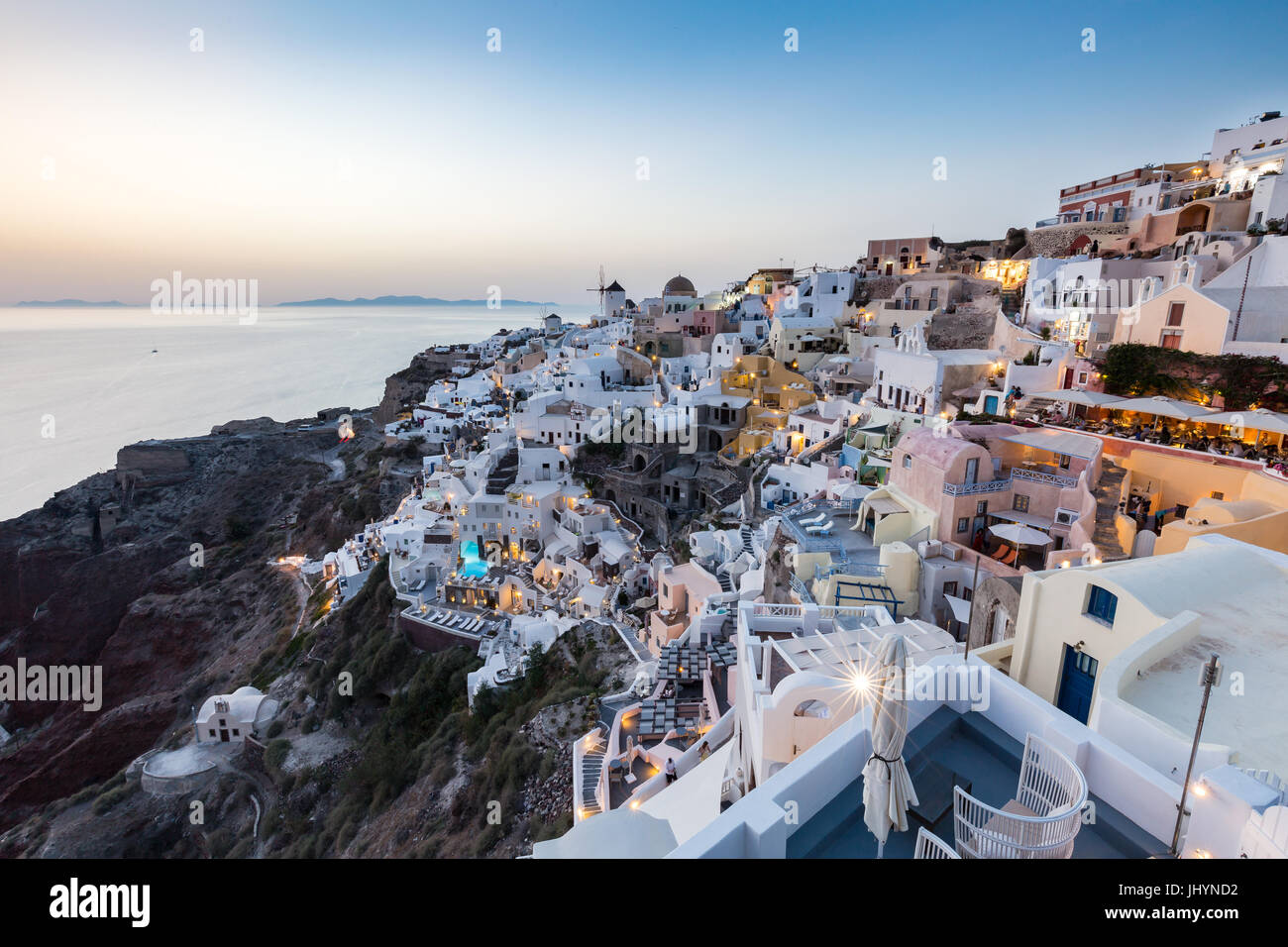 Blick auf den Sonnenuntergang über den weiß getünchten Gebäuden und Windmühlen von Oia, Santorini, Kykladen, griechische Inseln, Griechenland, Europa Stockfoto