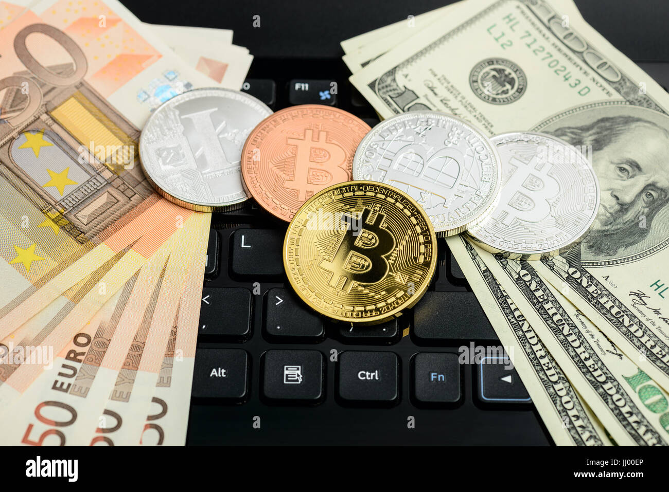 Bitcoin und Litecoin Münzen mit US-Dollar und Euro-Banknoten auf schwarzen Notizblock Tastatur Stockfoto