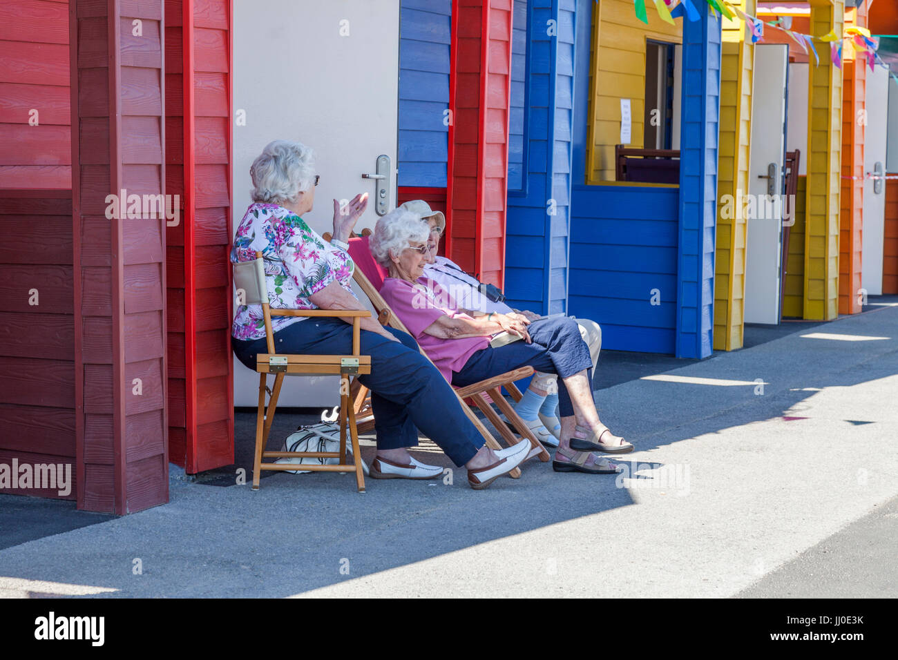 Drei Reife Frauen saßen auf Stühlen außerhalb einer Strandhütte am Saltburn am Meer, England, UK Stockfoto