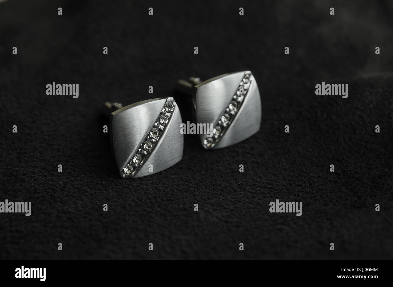 Silber Manschettenknöpfe mit Edelsteinen sind schräg auf die Dunkle Materie entfernt Stockfoto