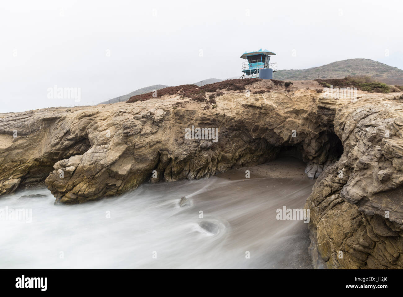 Rettungsschwimmer-Turm über Felsenbucht mit Motion blur Wasser Leo Carrillo State Beach in Malibu, Kalifornien. Stockfoto