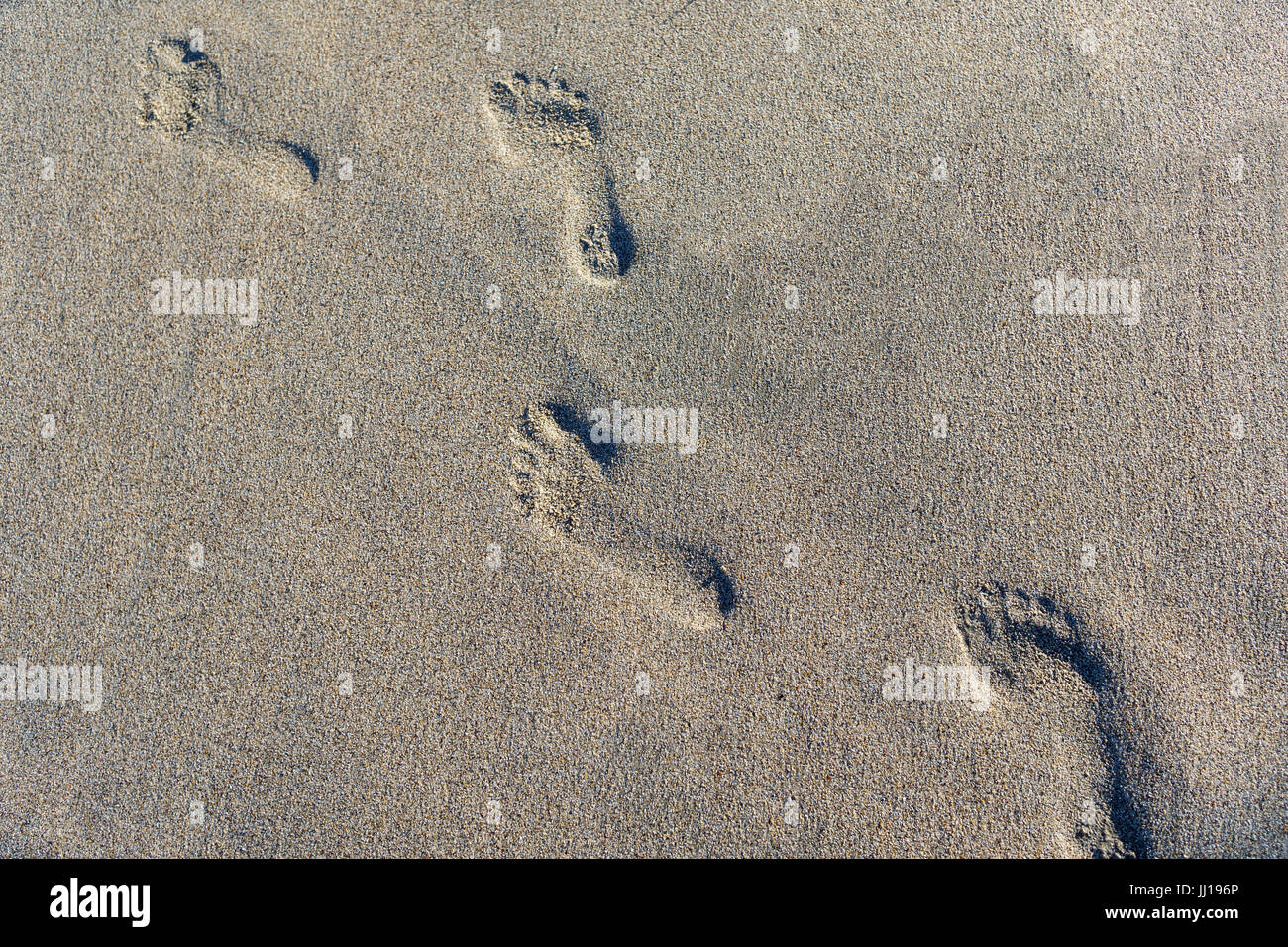 Fußabdrücke auf Strandsand Stockfoto