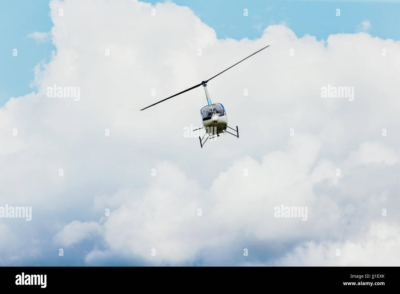 Hubschrauber fliegen im blauen Himmel und Wolken Stockfoto