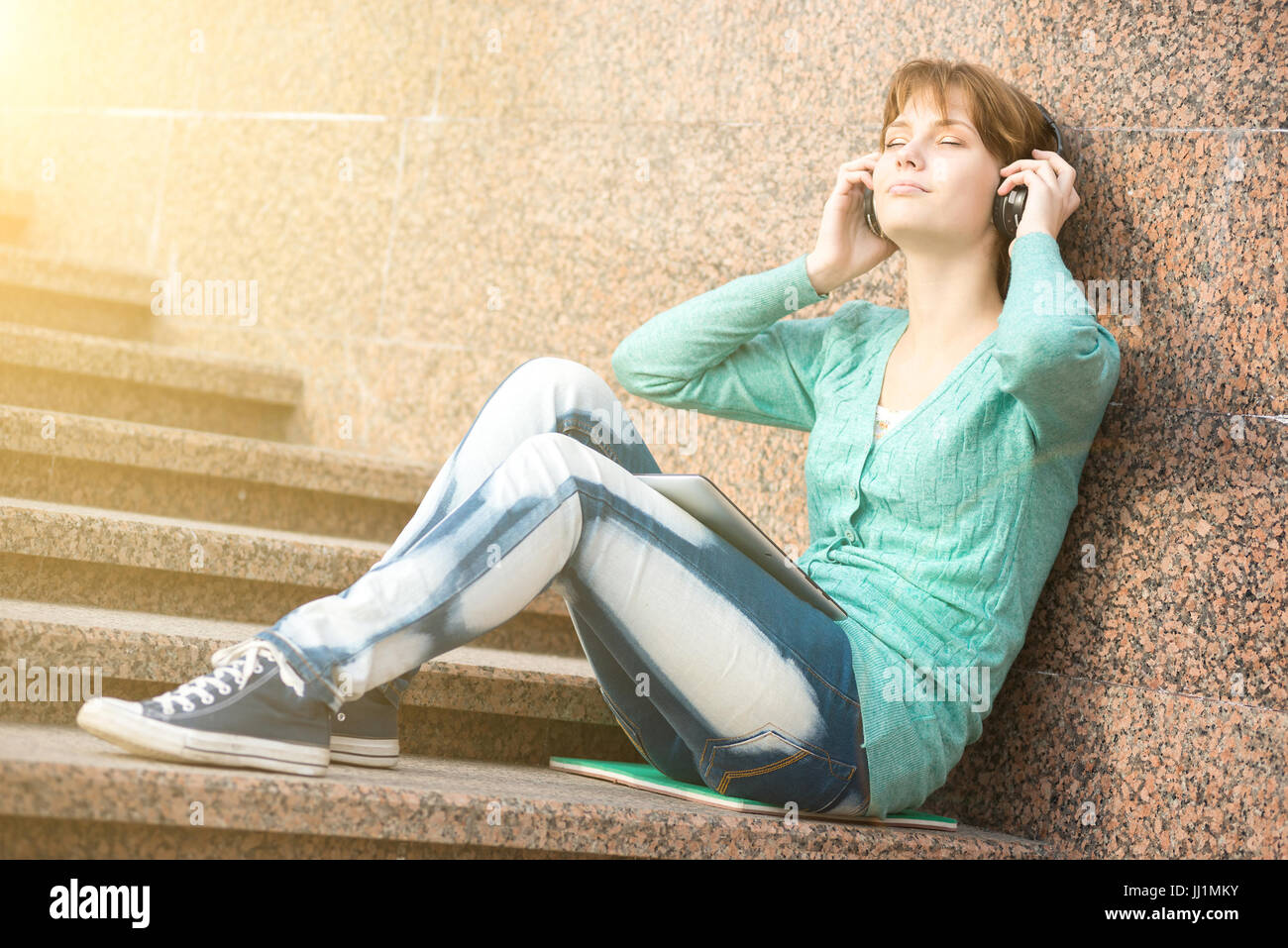 Schöne junge Frau Student mit Kopfhörer. Musik im freien-Mädchen Stockfoto