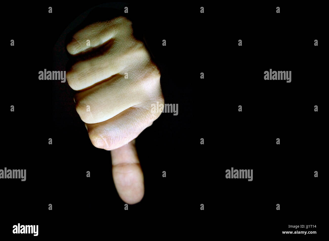 Hand mit Daumen nach unten isoliert auf schwarzem Hintergrund Stockfoto