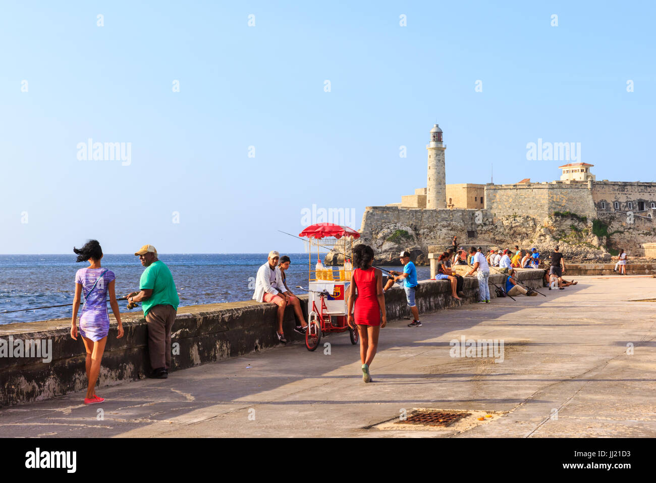 Kubaner entspannen Sie sich in der Nachmittagssonne auf dem Malecon, La Habana Vieja, Havanna, Kuba Stockfoto