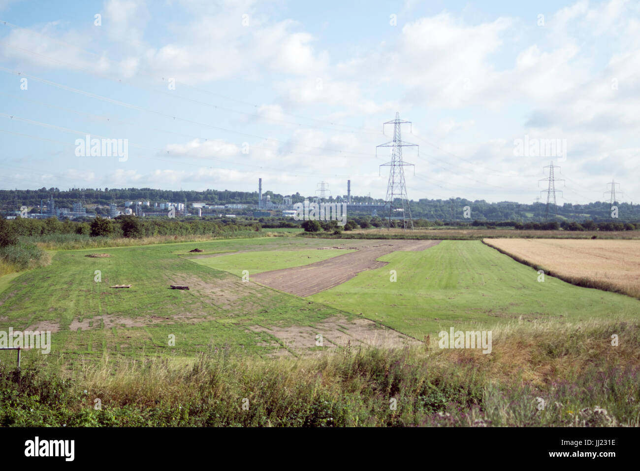 Pylonen und Windturbinen, die Strom erzeugen und an das nationale Netz verteilen. Stockfoto