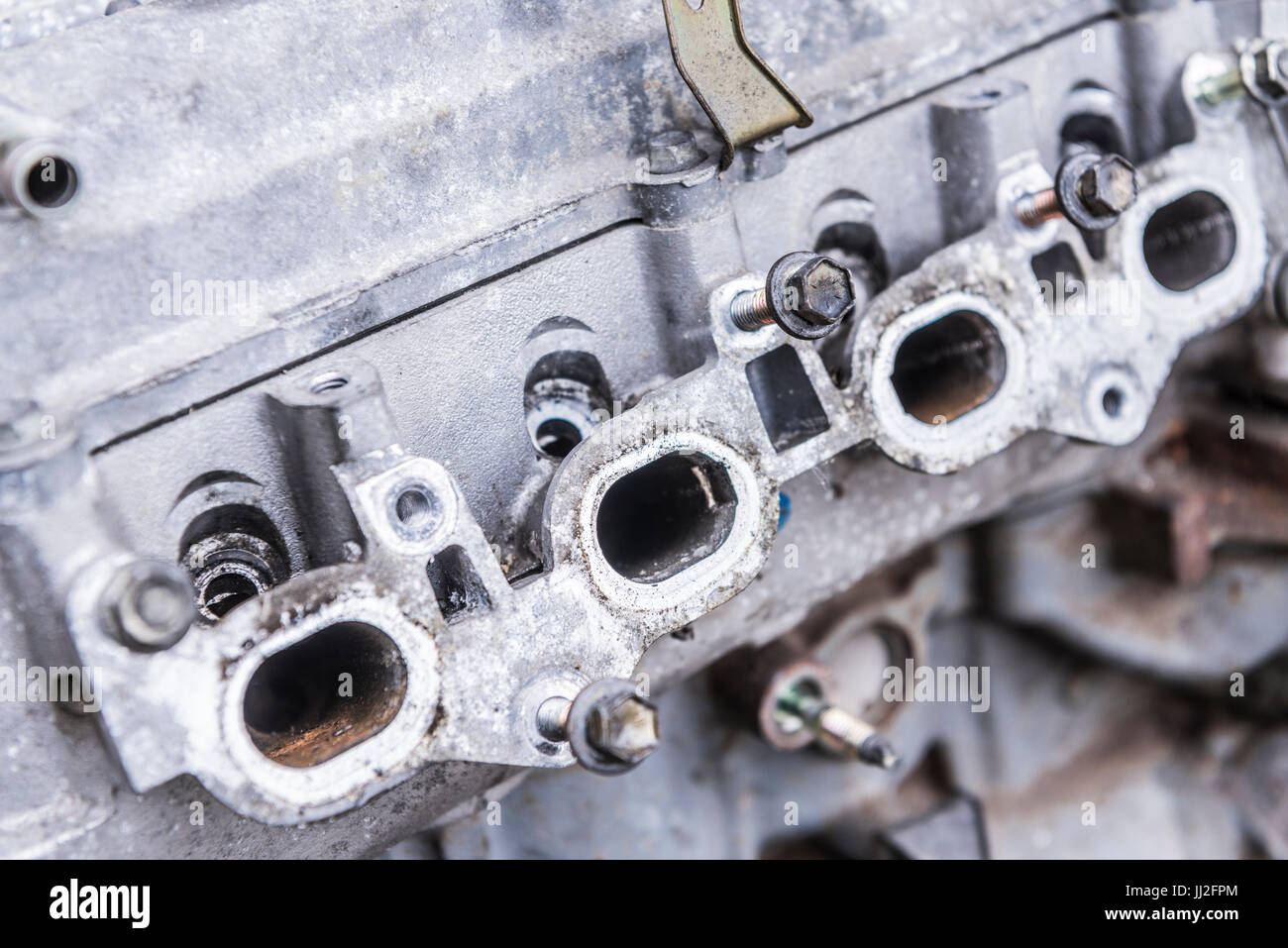Auspuff-Ausfahrt Gasentlastungsbohrungen auf einem alten Motorblock mit dem Abgaskrümmer entfernt. Stockfoto