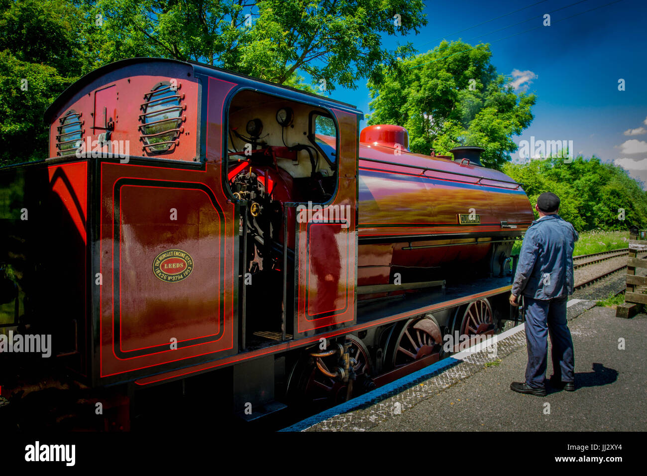 Dampfmaschine mit Lokführer.  Rot Dampflokomotive am streckenseitigen warten Stockfoto