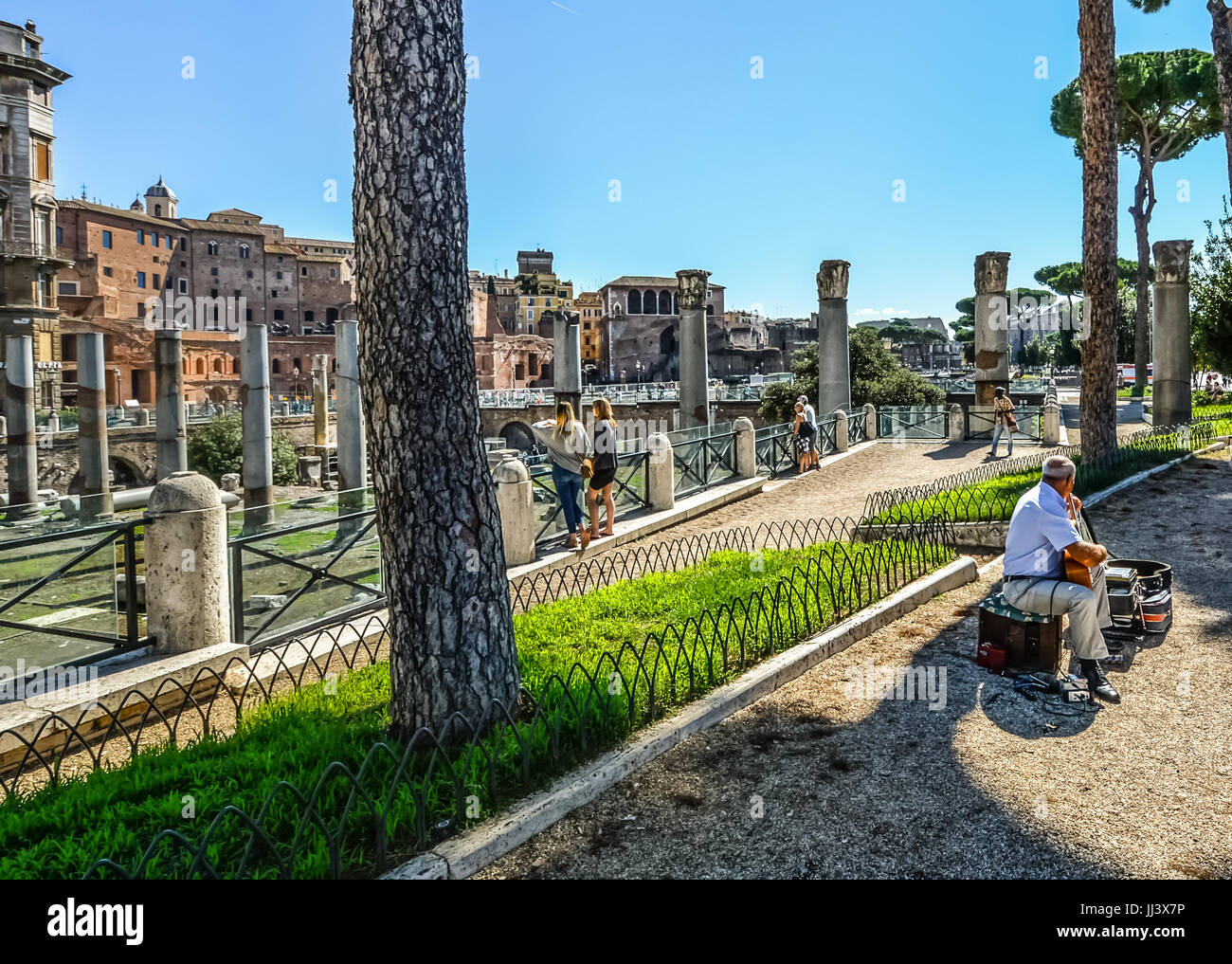 Straßenmusiker in Rom Italien als zwei junge Frauen genießen die alten römischen Ruinen in der Stadt Stockfoto