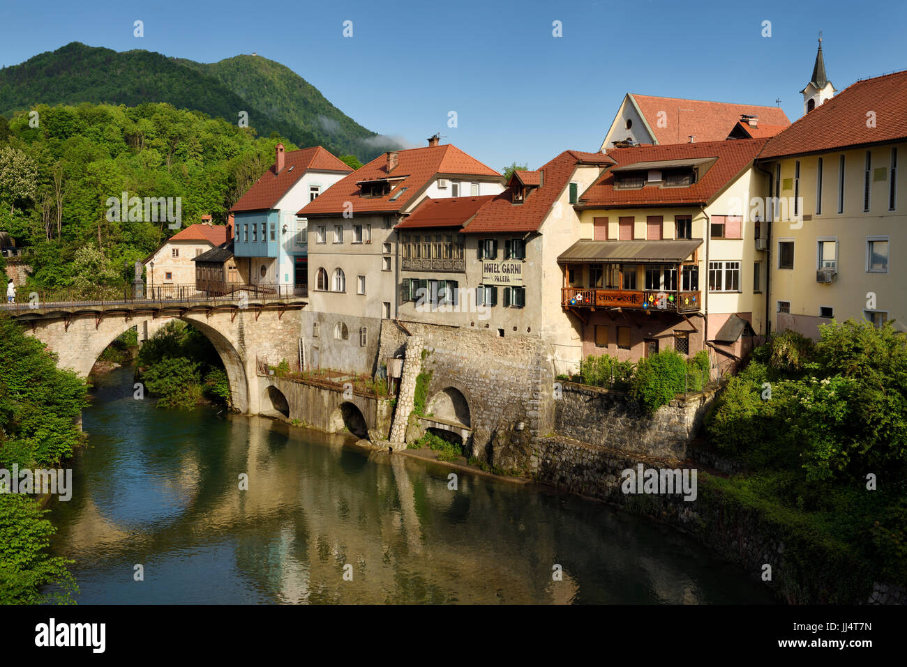 Kapuziner Stone Bridge und historische Häuser spiegelt sich im Fluss Selca Sora in Skofja Loka Dorf Slowenien Stockfoto