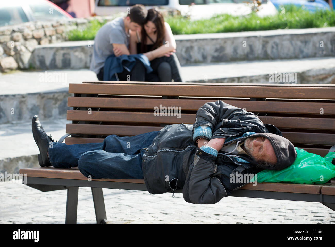Eine Obdachlose schlafen auf einer öffentlichen Bank in Sibiu, Siebenbürgen, Rumänien Stockfoto