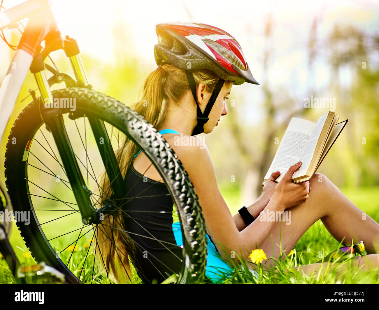 Fahrräder Radsport Mädchen trägt Helm Buch auf die Erholung in der Nähe von  Fahrrad Stockfotografie - Alamy