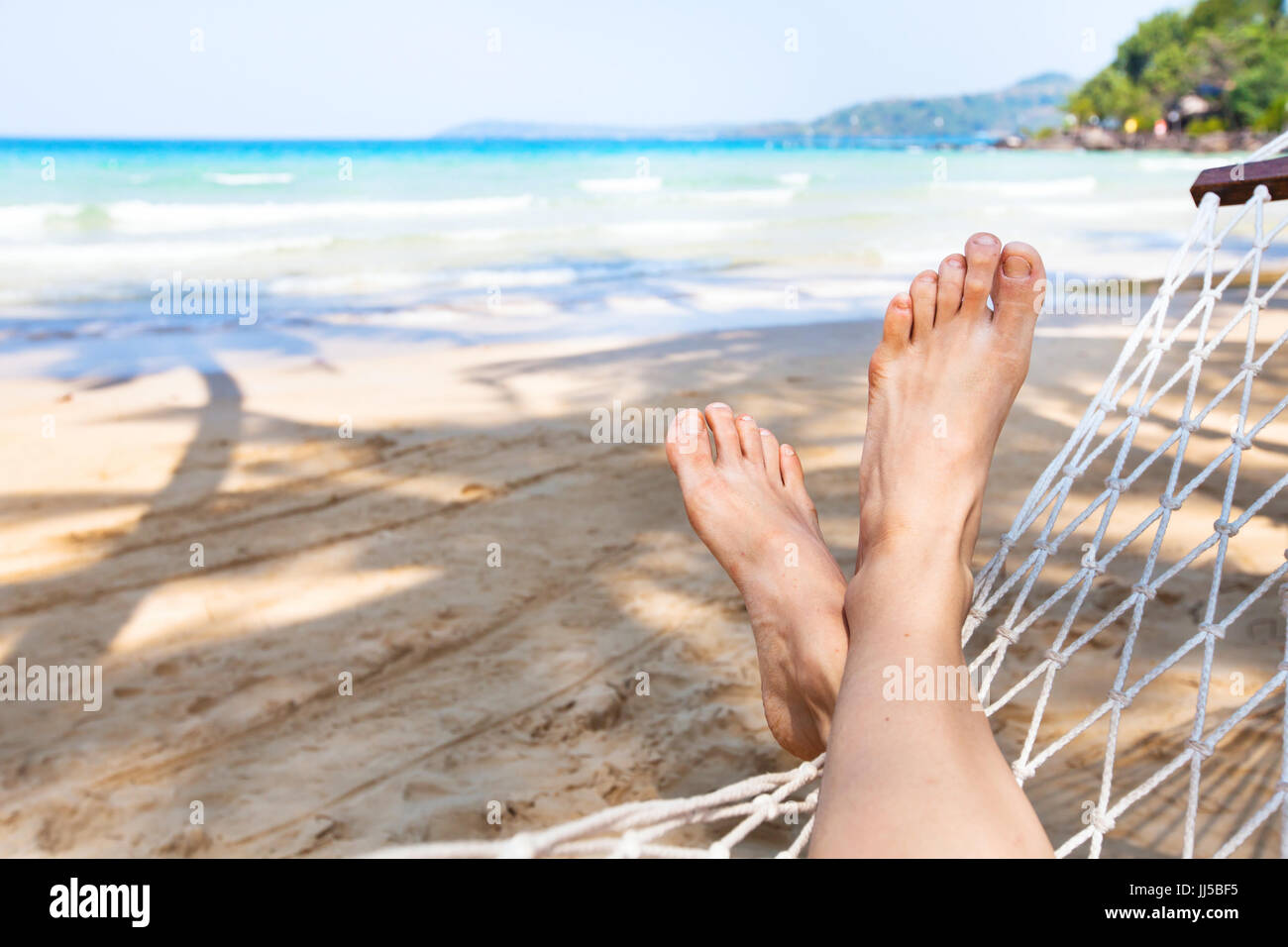 Strand Urlaub Hintergrund, Urlaub und Entspannung-Konzept, Füße der Person in Hängematte Stockfoto