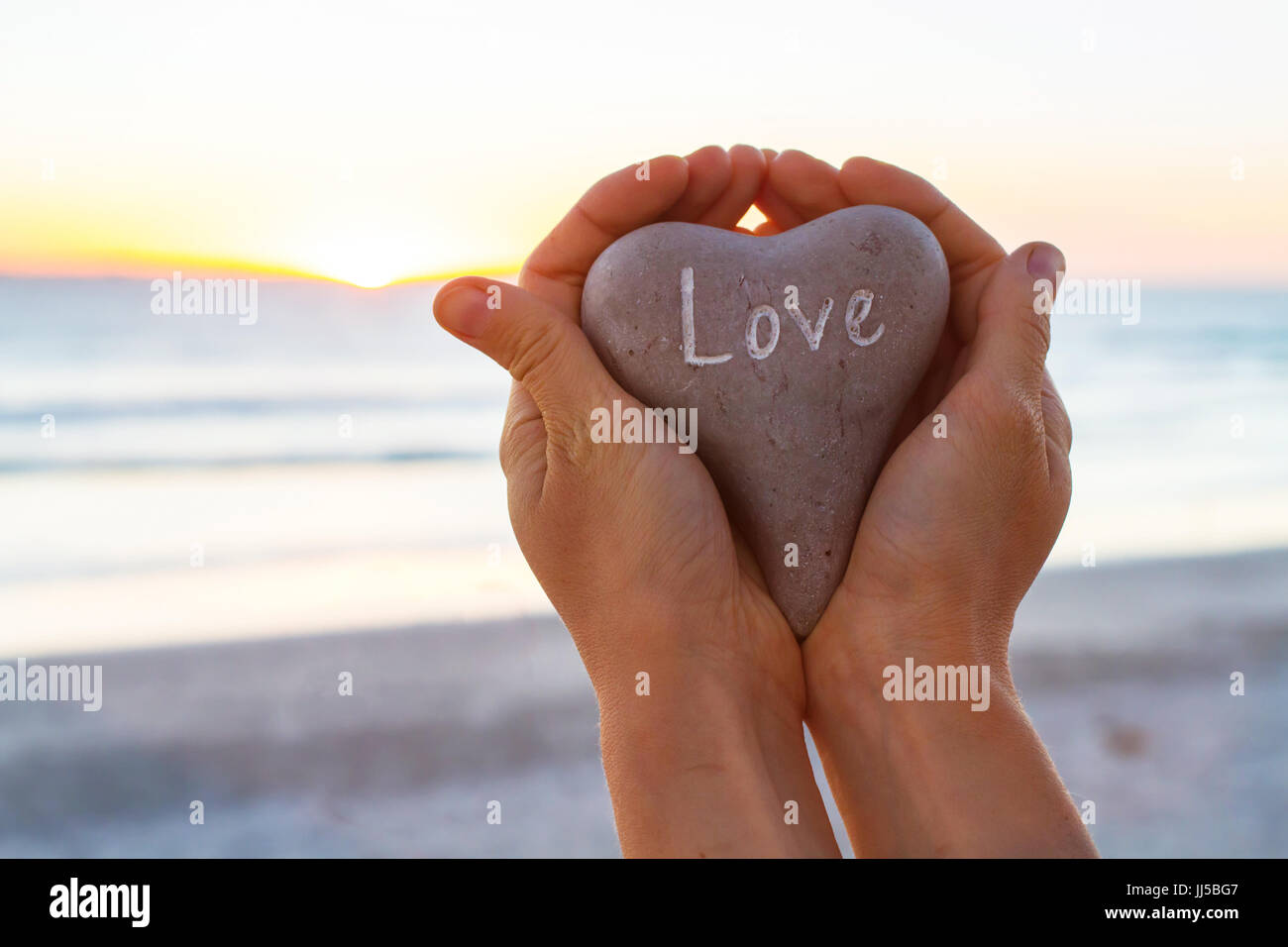 Liebe Konzept, Hände, Herzen Holding im Sunset Beach Stockfoto