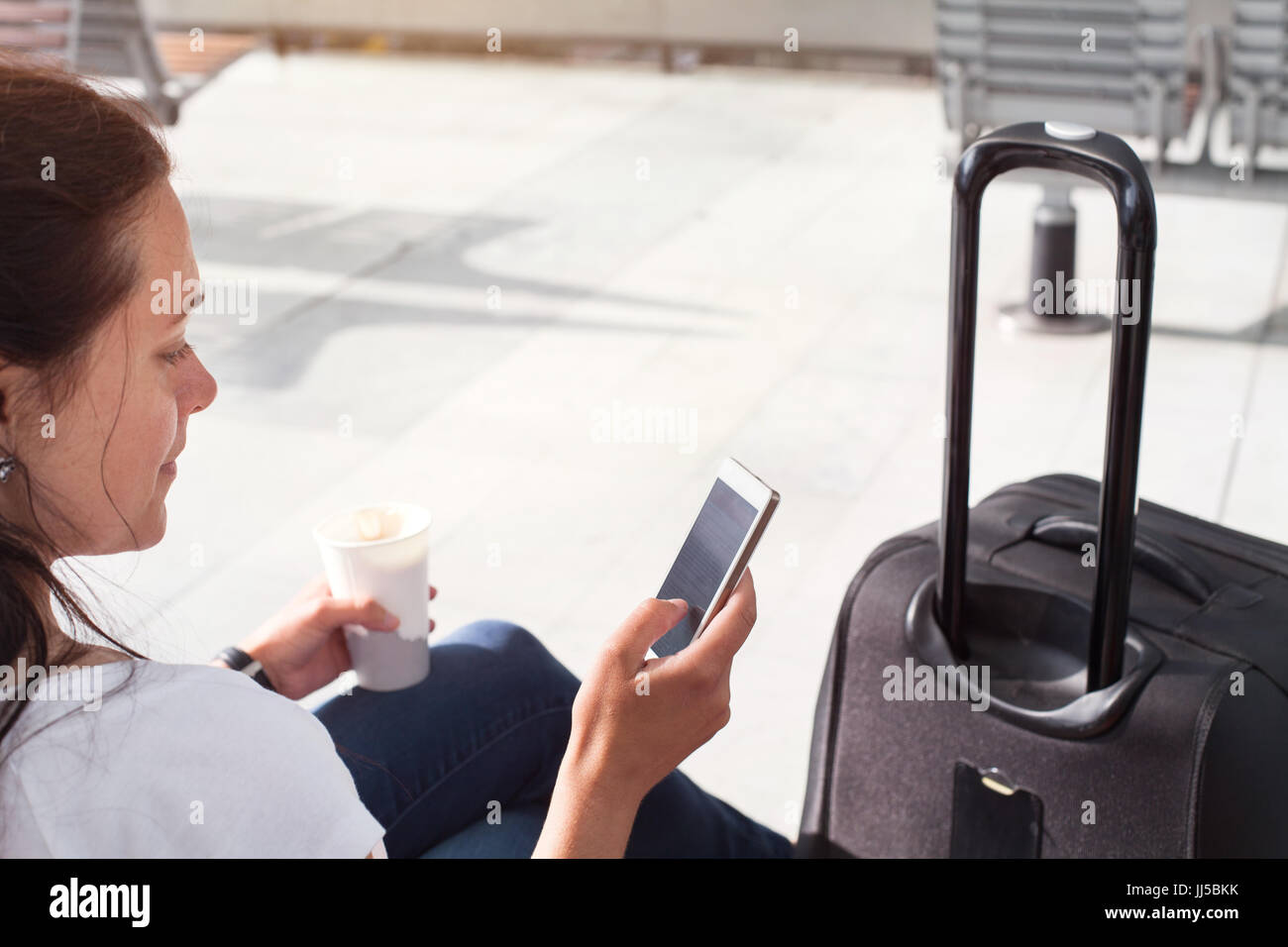 Frau Passagier mit mobile Internet oder WLAN auf ihrem Smartphone im Flughafen oder im modernen Bahnhof Stockfoto