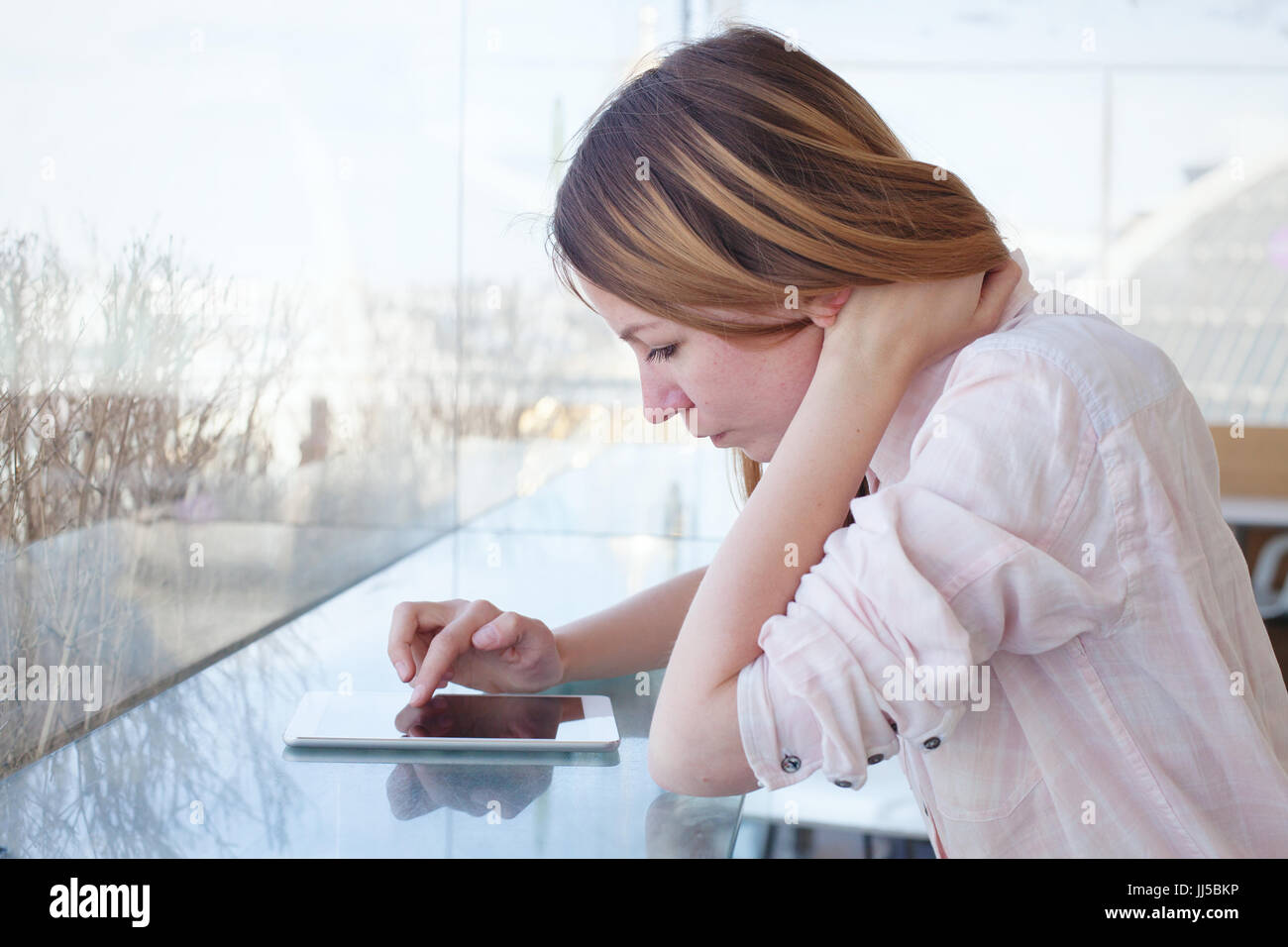 Junge Frau mit digitalen tablet Gadget in modernen Interieur, E-Mails und soziale Netzwerke online Stockfoto