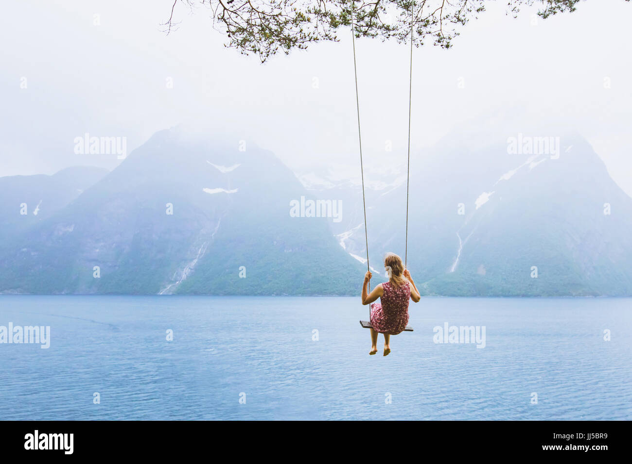 romantisch schöne Mädchen auf Schaukel in Norwegen, glückliche Träumer, Inspiration Hintergrund Stockfoto