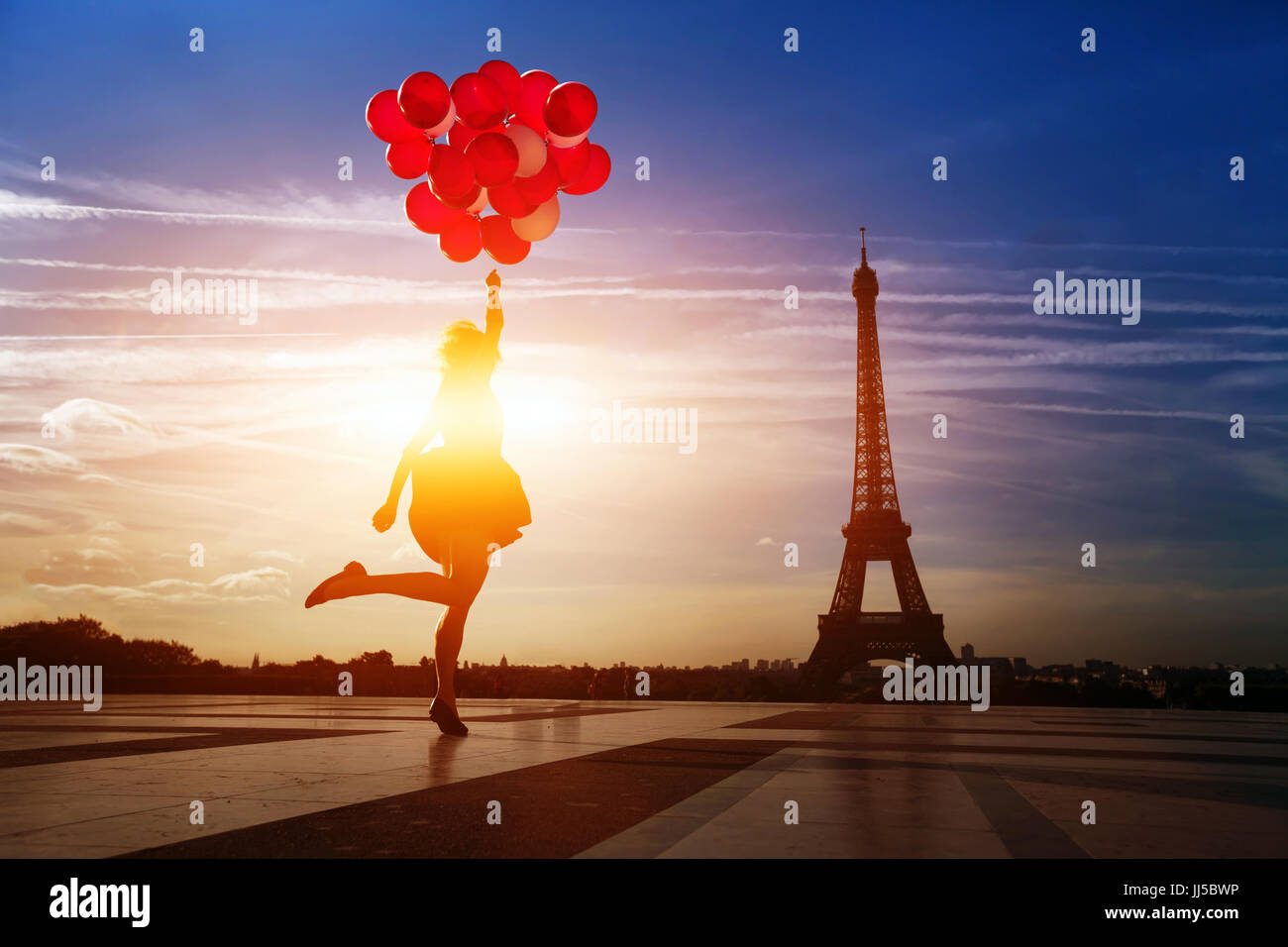 Glückliche Frau mit roten Ballons springen in der Nähe von Eiffelturm in Paris. Stockfoto